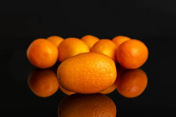 Kumquat laranja fresco isolado em vidro preto — Fotografia de Stock