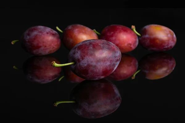 Prune bleue fraîche isolée sur verre noir — Photo