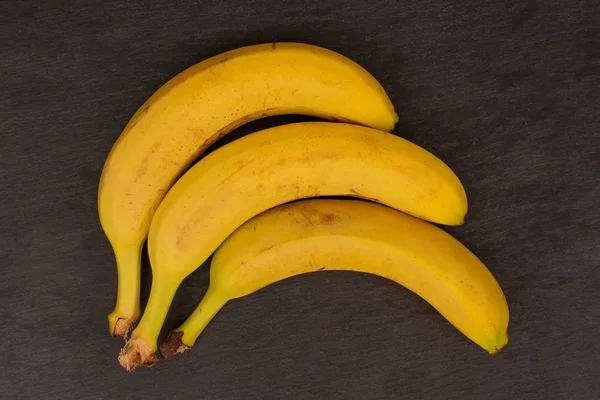 Banana amarela madura sobre pedra cinzenta — Fotografia de Stock