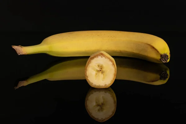 Banana amarela madura isolada em vidro preto — Fotografia de Stock