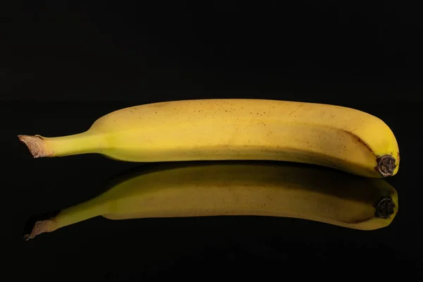 Banana amarela madura isolada em vidro preto — Fotografia de Stock