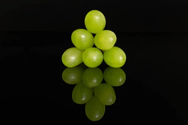 Frische grüne Trauben isoliert auf schwarzem Glas — Stockfoto