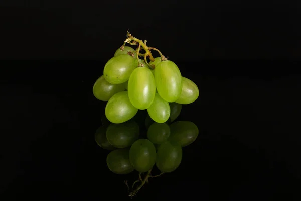 Fresh green grape isolated on black glass — Stock Photo, Image