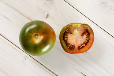Gri ahşap üzerine yeşilimsi kırmızı domates