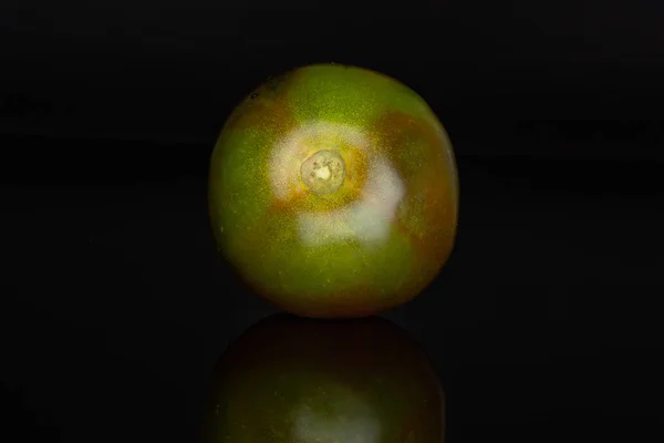 Yeşilimsi kırmızı domates siyah cam izole — Stok fotoğraf