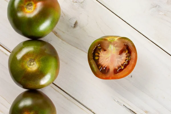 Tomate vermelho esverdeado sobre madeira cinzenta — Fotografia de Stock