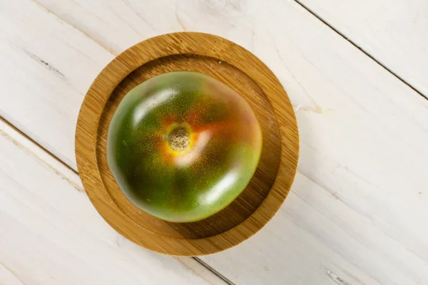 Tomate rojo verdoso sobre madera gris — Foto de Stock