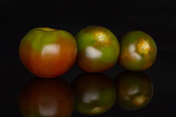 Pomodoro rosso verdastro isolato su vetro nero — Foto Stock