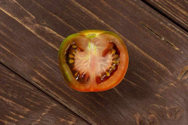 Grünlich rote Tomate auf braunem Holz — Stockfoto