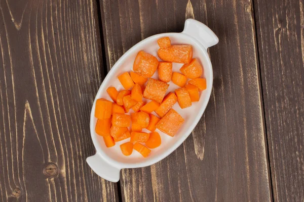 Orange baby carrot isolated on brown wood — Stock Photo, Image