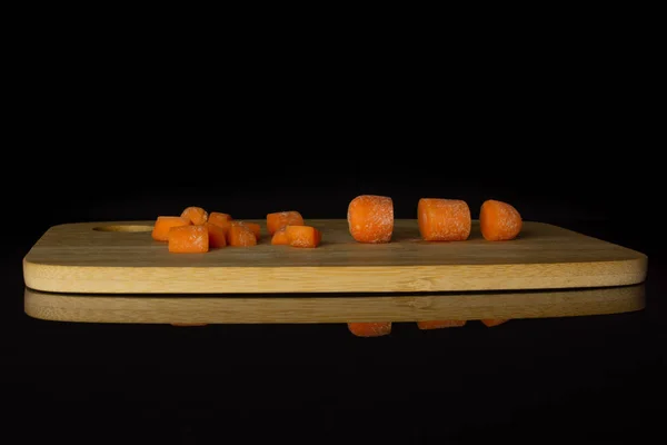 Cenoura de bebê laranja isolada em vidro preto — Fotografia de Stock