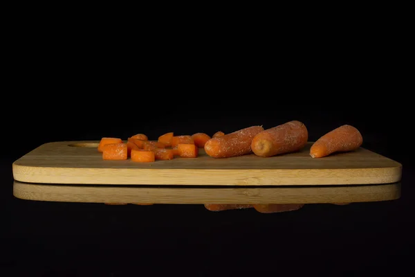 Orange baby carrot isolated on black glass — Stock Photo, Image