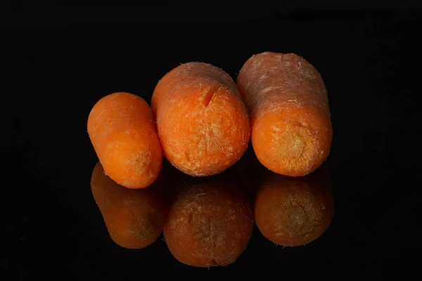 Oranžový kojenej Karotka izolovaný na černém skle — Stock fotografie