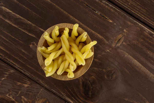 Raw pasta gemelli on brown wood — Stock Photo, Image