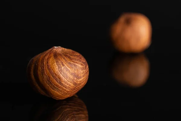 Стиглі коричневі лісові горіхи ізольовані на чорному склі — стокове фото