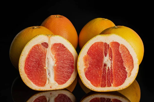 Frische rosa Grapefruit isoliert auf schwarzem Glas — Stockfoto