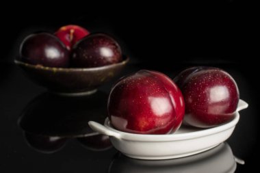 Olgun kırmızı erik siyah cam izole