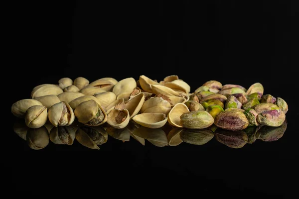 Green salted pistachio isolated on black glass — Stock Photo, Image