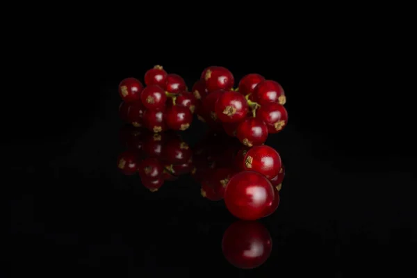Grosella roja fresca aislada en vidrio negro —  Fotos de Stock