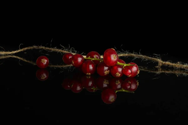Groselha vermelha fresca isolada em vidro preto — Fotografia de Stock