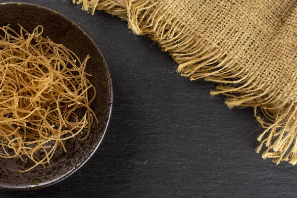 Gri taş üzerinde çiğ ince erişte