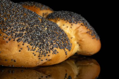 Siyah cam üzerinde izole bükülmüş haşhaş tohumu çörek