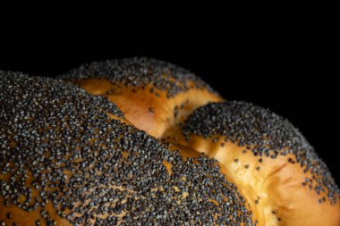 Siyah cam üzerinde izole bükülmüş haşhaş tohumu çörek