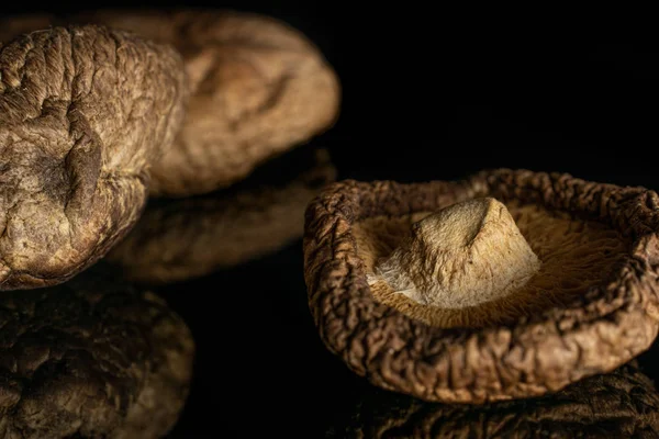 Dry shiitake mushroom isolated on black glass — Stock Photo, Image