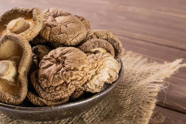 Dry shiitake mushroom on brown wood — Stock Photo, Image