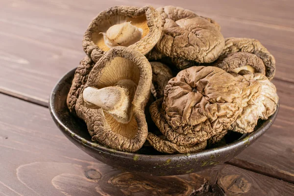 Dry shiitake mushroom on brown wood — Stock Photo, Image