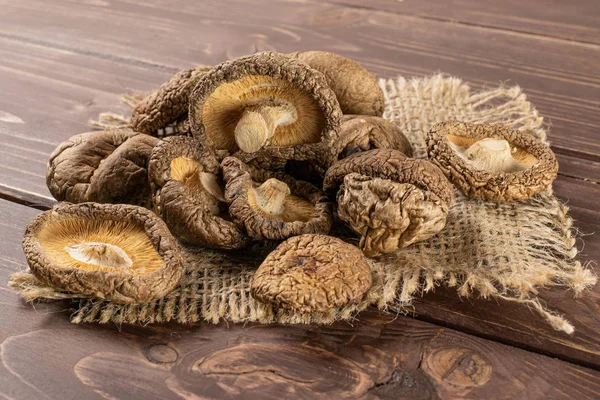 Dry shiitake mushroom on brown wood — Stock Photo, Image