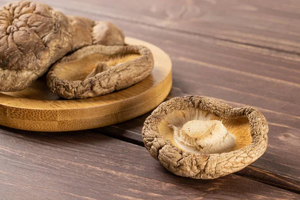 Dry shiitake mushroom on brown wood — Stock Photo, Image