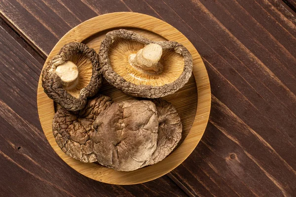 Dry shiitake mushroom on brown wood — Stock Photo, Image