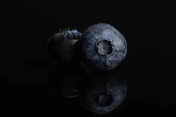 Fresj blauwe bosbes geïsoleerd op zwart glas — Stockfoto