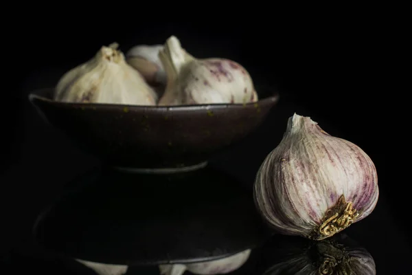 Weißer Bio-Knoblauch isoliert auf schwarzem Glas — Stockfoto