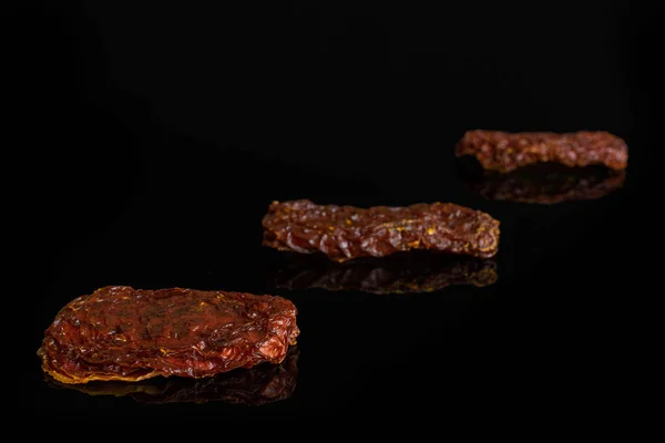 Red dried tomato isolated on black glass — Stock Photo, Image