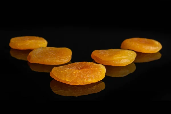 Sušený pomerančový meruňk izolovaný na černém skle — Stock fotografie