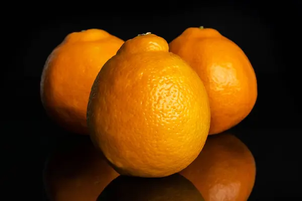 Orange minneola tangelo isoliert auf schwarzem Glas — Stockfoto