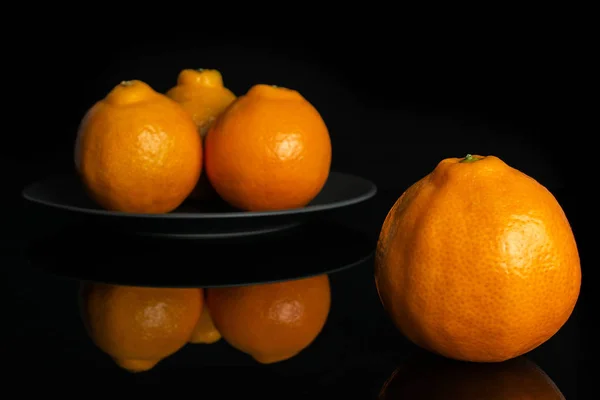 Orange minneola tangelo isolated on black glass — Stock Photo, Image