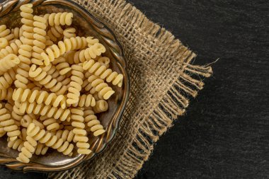 Gri taş üzerinde ham makarna fusilli bucati