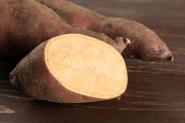 Patata dulce fresca sobre madera marrón — Foto de Stock
