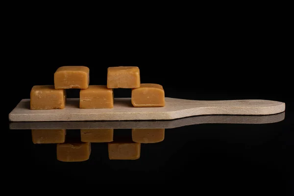 Sladký karamelové cukroví izolovaný na černém skle — Stock fotografie