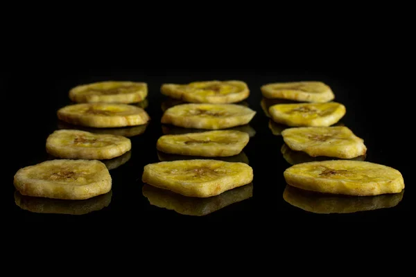 Yellow dry banana isolated on black glass — Stock Photo, Image
