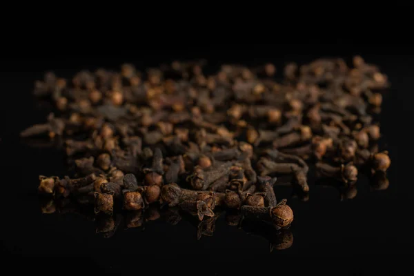 Dry brown clove isolated on black glass — Stock Photo, Image