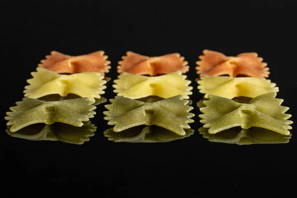 Surový Farfalle Tricolore izolovaný na černém skle — Stock fotografie