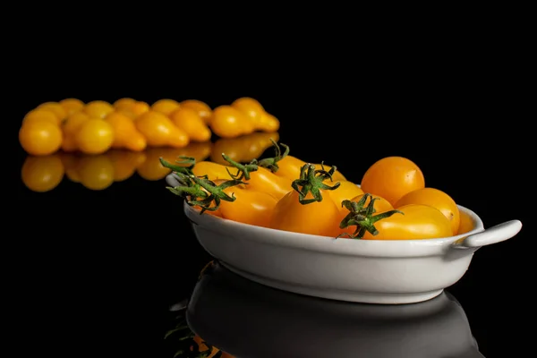 Yellow pear tomato isolated on black glass — Stock Photo, Image