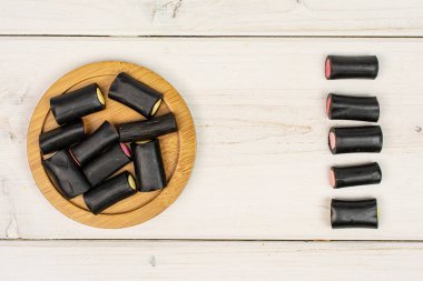Gri ahşap üzerinde siyah meyan kökü şeker