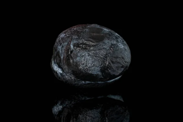 Secado ciruela oscura aislada en vidrio negro — Foto de Stock