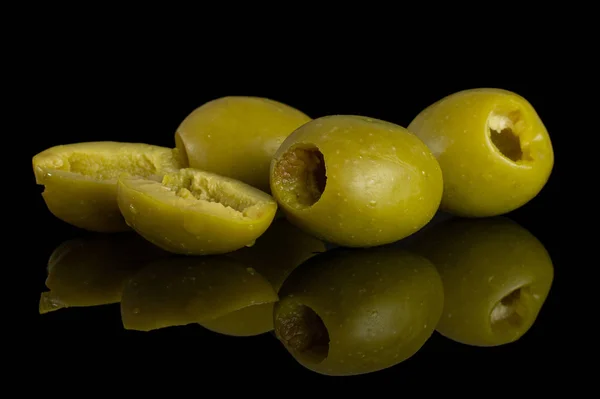 Ontpitte groene olijf geïsoleerd op zwart glas — Stockfoto