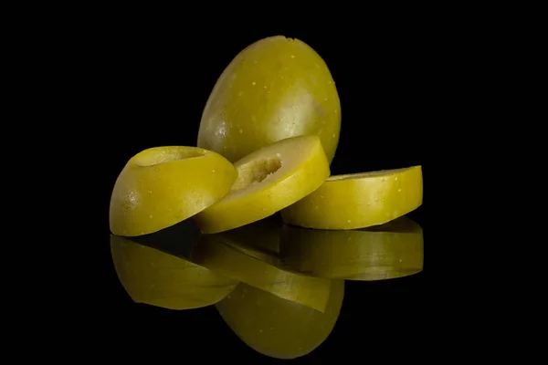 Entsteinte grüne Olive isoliert auf schwarzem Glas — Stockfoto